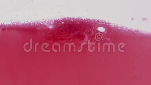 玻璃中起泡的粉红色液体表面视频的预览图