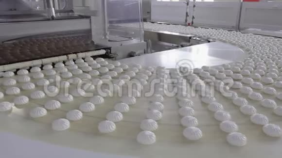 有很多白色棉花糖的传送带进入巧克力涂层装置视频的预览图