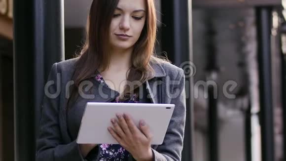 这位年轻漂亮的女商人在日落时分在街道上使用平板电脑的特写镜头视频的预览图