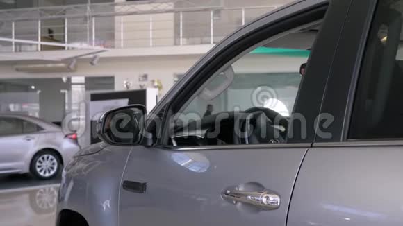 快乐的新车主人微笑的亚洲消费者女性展示钥匙坐在沙龙透过窗户偷看视频的预览图