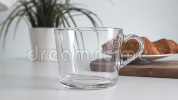 将热茶倒入白色厨房桌子上的玻璃杯中快关门视频的预览图