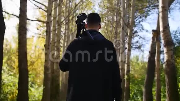 摄影师在森林里用三脚架视频的预览图