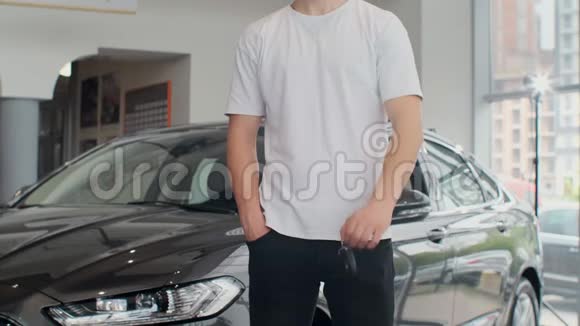一名男性顾客拿着他新买的车钥匙的中间部分的镜头有人拿着车钥匙视频的预览图
