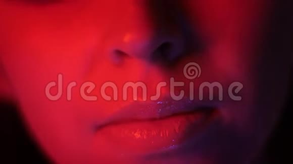 夜店的红色霓虹灯和bokeh背景的漂亮女性嘴唇特写镜头视频的预览图