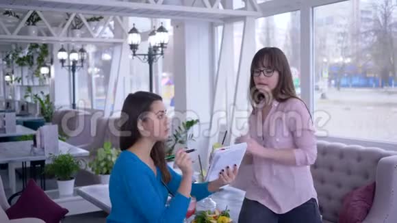 饮食计划年轻女性为了减肥一起在咖啡馆写下健康的蔬菜饮食视频的预览图