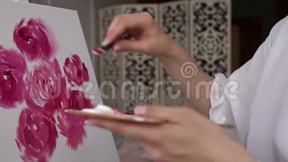 特写女孩用画笔在画布上画牡丹特写视频的预览图