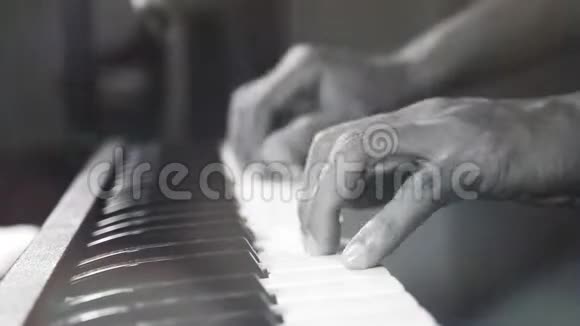 4K镜头的音乐钢琴家手在夜总会弹钢琴聚光灯和光线泄漏乐器视频的预览图