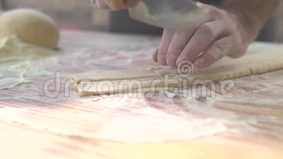 制作自制面食的特写过程厨师用刀切意大利传统面食新鲜面团视频的预览图