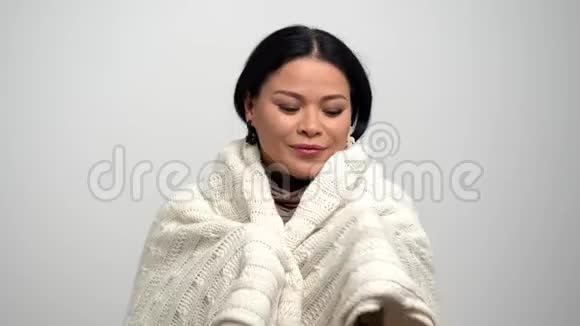 可爱的亚洲女人被白色围巾裹得暖暖的视频的预览图