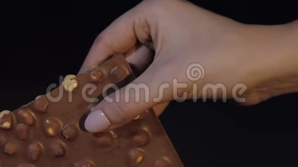 女人手中的黑巧克力块特写视频的预览图