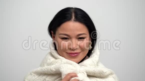 可爱的亚洲女人被白色围巾裹得暖暖的视频的预览图