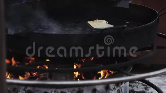 一个厨师手戴黑色橡胶手套用桨翻转煎饼视频的预览图