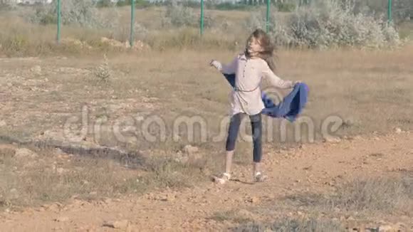 难民女孩在难民营的垃圾地上玩耍女孩手里拿着毯子跳舞贫穷和幸福概念视频的预览图