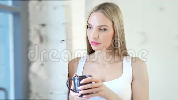 中等身材的特写镜头年轻的欧洲女性看着窗户看着白色的阁楼内部视频的预览图