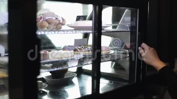 一只雌性手从冰箱里拿出一盘甜甜圈视频的预览图