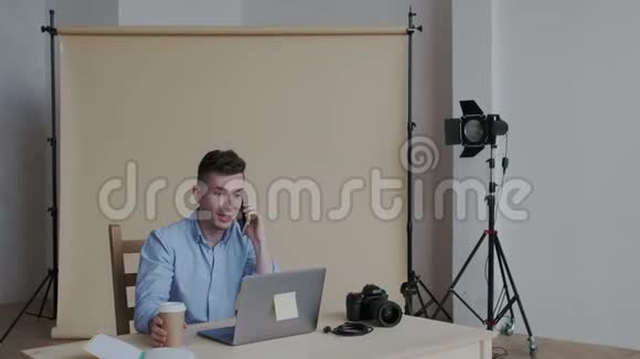 情感快乐时尚的男人在电话里和客户说话他是自由摄影师卖他的服务他是视频的预览图