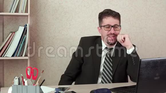 办公室经理带胡须和眼镜的人通过笔记本电脑的视频链接交谈视频的预览图