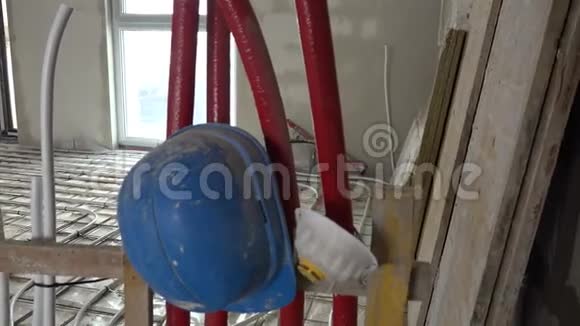 地下供暖系统管道和施工现场的蓝色头盔视频的预览图