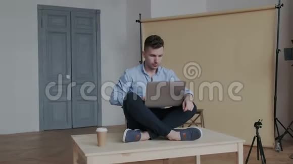 当他坐在桌上的莲花位置上手提电脑和工作时照相机在创意商人的周围移动视频的预览图