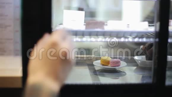 一个盘子的特写橱窗后面有三个马卡龙视频的预览图