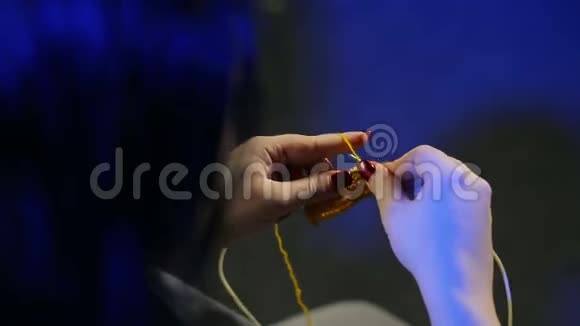 女人手拿着针织针用黄线编织视频的预览图