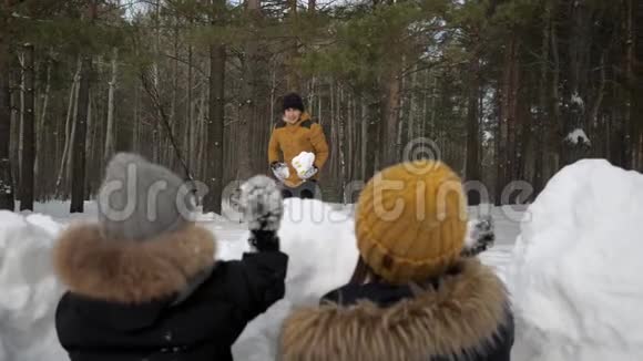 男人正在和家人玩雪球妻子和小儿子躲在雪墙前视频的预览图
