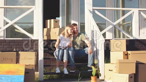 丈夫和妻子站在新买的房子前面带着盒子视频的预览图