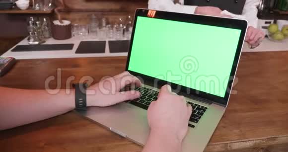 男人用绿色屏幕在笔记本电脑上快速打字视频的预览图
