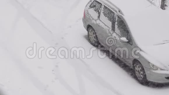 车在雪地里停车场雪中的脚印暴风雪冬天降雪视频的预览图