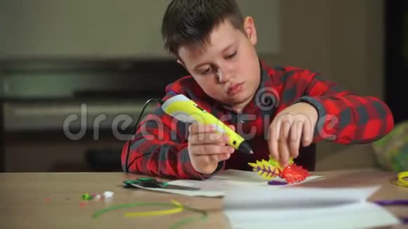 男孩创作一朵塑料花使用3D笔他有创造性地学习视频的预览图