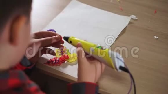 青少年男孩使用3D笔他把图形的碎片粘在一起创造了一朵塑料花视频的预览图