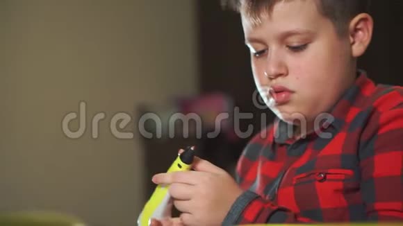 青少年男孩使用3D笔他把图形的碎片粘在一起创造了一朵塑料花视频的预览图