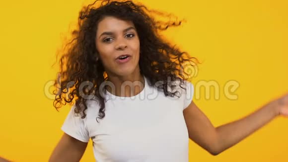 积极的年轻女性在黄色背景下跳舞享受快乐的心情视频的预览图