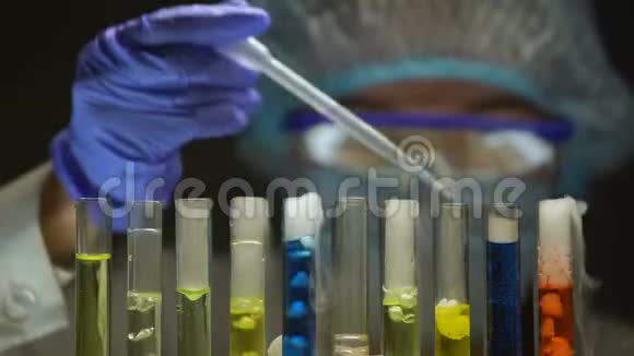 化学家用黄色液体检查管内的沉淀物冒烟物质视频的预览图