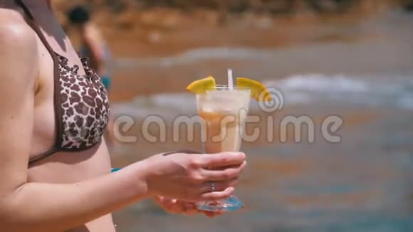 埃及海滩上穿着泳衣手拿异国鸡尾酒的年轻女孩视频的预览图