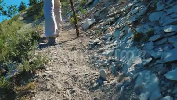 女孩旅行者在山上的一条尘土飞扬的小径上视频的预览图