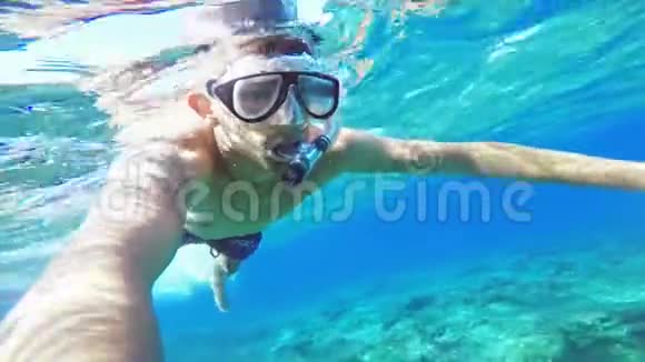 水下赛尔夫年轻人在海中戴着水下面具游泳视频的预览图