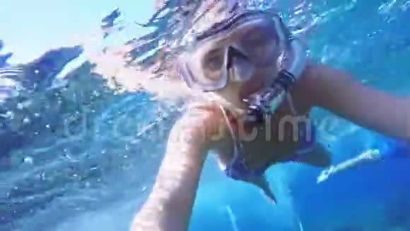 水下自拍女人潜水在浮潜潜水面具和浮潜在清澈的蓝色海水视频的预览图