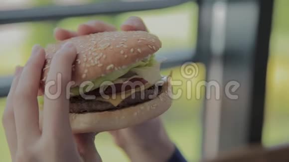 漂亮的女孩手里拿着汉堡快餐店视频的预览图