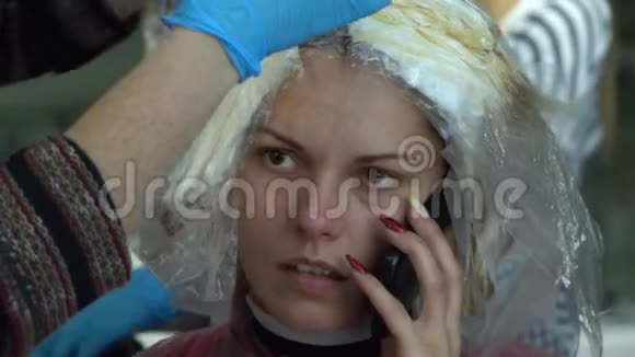 美容院理发店设计师给他的客户画头发女孩坐在镜子前的椅子上女孩视频的预览图