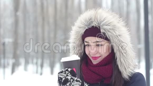 美丽的年轻女孩在浪漫的心情中喝咖啡在冬天的公园里等她的男朋友视频的预览图