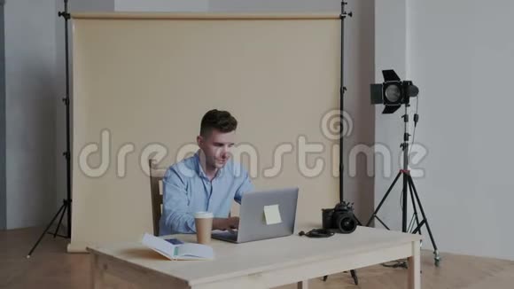 专业摄影师在他的个人电脑上的照片编辑应用程序中工作快乐的男人整理图片看视频的预览图