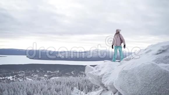 迷人的女人正张开双臂站在雪山的边界上视频的预览图