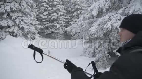 在美丽的冬季森林里带绿色袋子的滑雪者视频的预览图