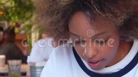 波特雷特年轻的一个黑人女学生被她在咖啡馆的家庭作业所淹没背景组快乐学生视频的预览图
