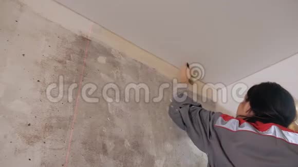 女人在墙上涂壁纸胶视频的预览图
