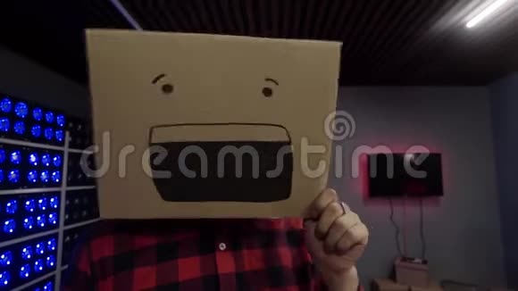 在摄影棚里一个可爱的有趣的家伙把纸盒放在头上脸上带着微笑视频的预览图