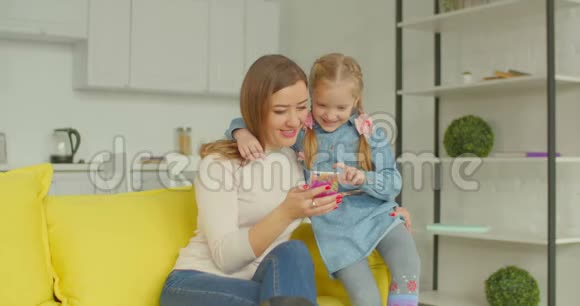 妈妈和可爱的女孩用手机上网视频的预览图