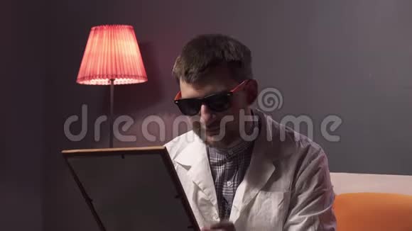 有魅力的人带着墨镜和白色的实验室拿着画框视频的预览图