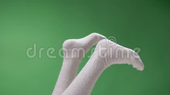 穿着可爱的白色膝袜的少女美脚特写镜头在绿色的环境下双脚背被隔离视频的预览图